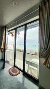 a room with a large window with a view of the ocean at La Maison Hòn Sơn in Lai Sơn
