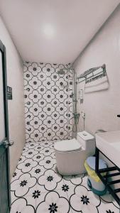 a bathroom with a white toilet and a black and white tiles at La Maison Hòn Sơn in Lai Sơn +65 photos