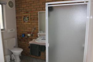 a bathroom with a toilet a sink and a shower at The Balnarring Motel in Balnarring