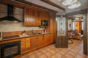 a kitchen with wooden cabinets and a sink at Villa De Urueña Casa de Ilustres in Urueña +28 photos