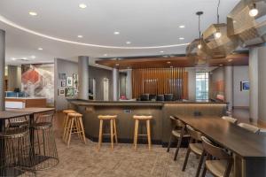 a restaurant with a bar with stools and tables at SpringHill Suites by Marriott Downtown Chattanooga/Cameron Harbor in Chattanooga