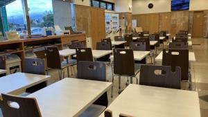 Toyoko Inn Yonezawa Ekimae في يونيزاوا: غرفه فاضيه فيها طاولات وكراسي