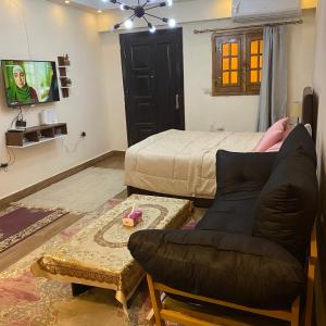 un salon avec un lit et un canapé dans l'établissement Studio near airport, au Caire
