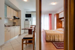 cocina y dormitorio con cama y mesa en Apartment Tafra 3, en Lokva Rogoznica