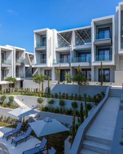 an external view of a building with tables and umbrellas at Apartment Alexandar15 in Nikiti