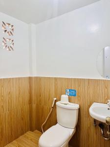 a bathroom with a toilet and a sink at Amancio's Tourist Inn-Close to the Airport in Puerto Princesa City