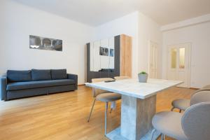 ein Wohnzimmer mit Tisch und Couch in der Unterkunft Cozy 1BR apartment near Opera - 24h self check-in in Wien