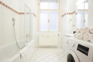 ein weißes Bad mit einer Dusche und einer Waschmaschine in der Unterkunft Cozy 1BR apartment near Opera - 24h self check-in in Wien