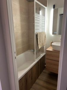 ein Badezimmer mit Badewanne und Waschbecken in der Unterkunft Les Marmottes in Montgenèvre