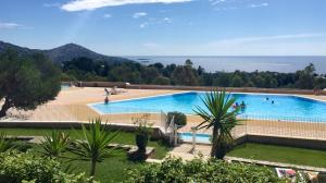 a large swimming pool with a view of the ocean at Appartement 4 personnes Cap Estérel centre du village in Saint-Raphaël