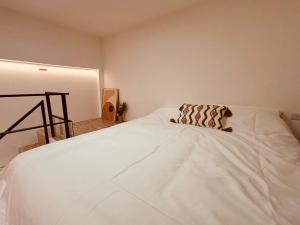 een wit bed met een kussen erop bij 礁溪 Hao Hao in Jiaoxi