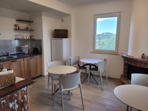 a kitchen with two tables and chairs and a window at Alchemilla Bed & Breakfast in Offida