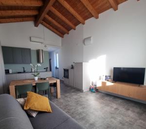 a living room with a couch and a table and a kitchen at Skyview Family Lodge in Mezzocorona