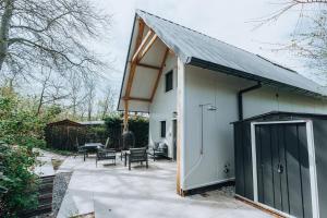 a house with a black door on a patio at Vuurtorenveld 134 - Het Oude Nieuwland Ouddorp in Ouddorp