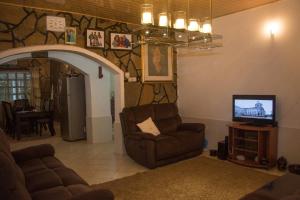 a living room with a couch and a tv at Reens Vacation Rentals in Nakuru