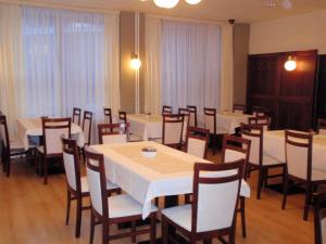 a dining room with white tables and chairs at Hotel Astra in Tuchlovice