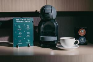 a coffee maker sitting on a counter next to a cup at River Hotel Hatyai in Hat Yai