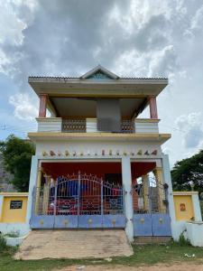 a house with a blue gate in front of it at Magizh Kudil in Pūrnānkuppam +5 photos