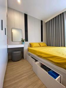 a bedroom with a yellow bed and a mirror at Vinhomes Smart City - Vinsmart Tây Mỗ - Homestay - Alo Homestay in Phú Thú