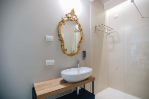 łazienka z umywalką i lustrem na ścianie w obiekcie Ponte dei Voltoni Apartment w mieście Peschiera del Garda +12 zdjęć