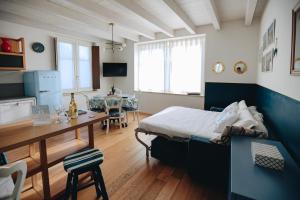 sypialnia z łóżkiem i biurkiem oraz jadalnia w obiekcie Ponte dei Voltoni Apartment w mieście Peschiera del Garda