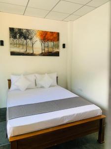 a bed in a room with a painting on the wall at Rock n Fall Nature Resort in Ella