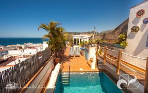 a resort with a swimming pool and the ocean at Casa Tropical in La Herradura