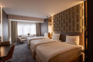 Tempat tidur dalam kamar di Nobel Design Hotel