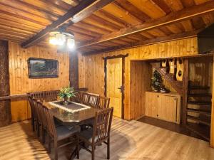 a dining room with a table and wooden walls at Kozarik in Mykulychyn