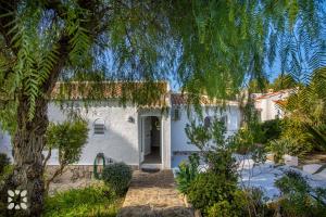 ein weißes Haus mit einem Baum davor in der Unterkunft Villa Buena Vida by Abahana Villas in Jávea