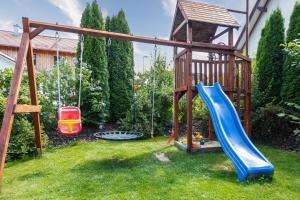 - une aire de jeux avec toboggan et balançoires dans la cour dans l'établissement Moderne Fewo mit Fasssauna und Kamin im ländl. Allgäu, à Eggenthal