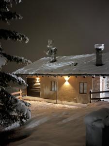 a house with a snow covered roof with lights on it at Ca' De Sass in Pila