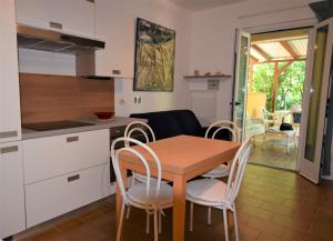 a kitchen and dining room with a wooden table and chairs at Susy, vicino alla spiaggia di Fetovaia in Fetovaia