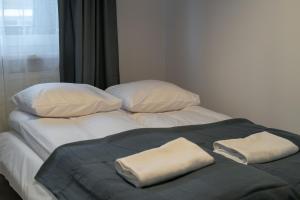 a large bed with two towels on top of it at RentPlanet - osiedle Kasprusie in Zakopane +16 photos