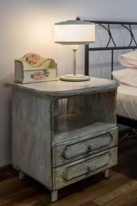 a lamp on top of a wooden table with a bed at RentPlanet - osiedle Kasprusie in Zakopane