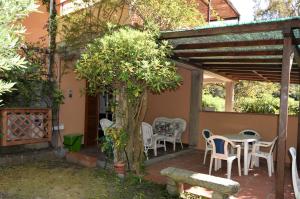 a patio with a table and chairs under a pergola at Susy, vicino alla spiaggia di Fetovaia in Fetovaia