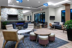 a lobby with tables and chairs and a fireplace at Residence Inn by Marriott Virginia Beach Town Center in Virginia Beach