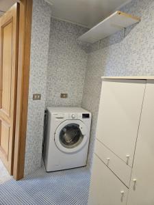 una lavatrice e un'asciugatrice in un piccolo bagno di Peter's Flat a Napoli Altre 2 foto