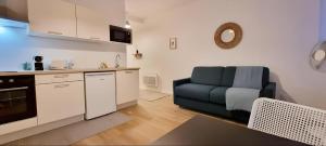 a kitchen with a blue couch in a living room at Large Studio lumineux et neuf, Parking Gratuit in Châteauroux