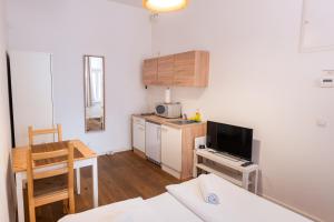a living room with a kitchen and a table with a television at Vienna City Apartments - Metro 1160 Vienna in Vienna