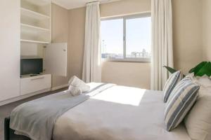 a bedroom with a large white bed with a large window at Harbour Bridge 33C in Cape Town