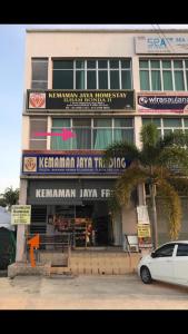 a building with a car parked in front of it at Ilham Bonda Homestay II LELAKI SAHAJA in Kampong Jaya