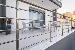 a balcony with white chairs and a table at Ramo Luxury Villa in Kremasti