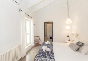 a white bedroom with a bed and a chair at Finca Calafi Nou by Sonne Villas in Cala Galdana +108 photos