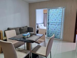 a dining room with a table and chairs and a couch at Neo2 condo B 204 in Jomtien Beach