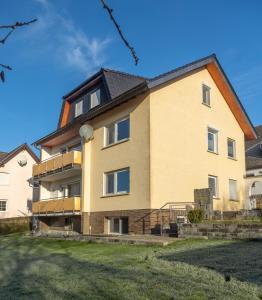 a large yellow building with a yard at Ferienwohnung MiA in Frankenau