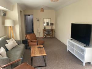a living room with a couch and a flat screen tv at Cambridge Water House Apartments in Cambridge