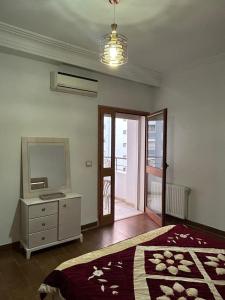 a bedroom with a bed and a dresser and a mirror at Lumineux Calme avec Parking Privé Proche La Marsa in Tunis