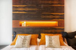 a bedroom with a wooden wall and a bed with pillows at Costa Rica Bibione SPA in Bibione