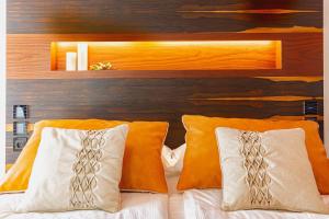a bedroom with a bed with orange and white pillows at Costa Rica Bibione SPA in Bibione +37 photos
